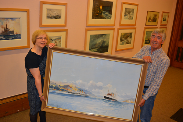 Museum Curator and Edward Yardley holding a Frank Henry Mason painting